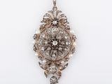 a close up of a diamond and pearl pendant on a white background