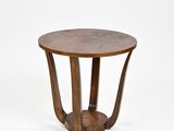 une table en bois avec un plateau rond et un piètement en bois