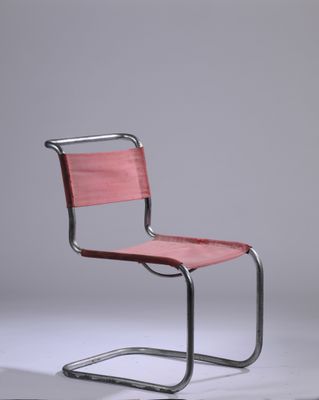 une chaise rouge posée sur un sol blanc
