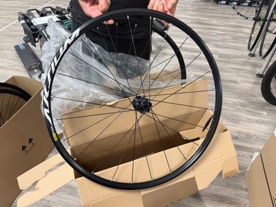 a man standing next to a bicycle wheel in a store