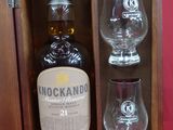 une bouteille de whisky et deux verres dans un coffret en bois