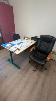 un bureau avec une chaise et un plateau sur lequel sont posés des papiers