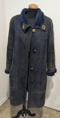 un manteau posé sur un mannequin devant un mur blanc