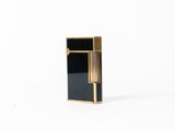 a black and gold lighter sitting on top of a white surface
