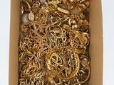 a box full of gold jewelry on a white surface