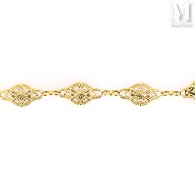 a close up of a gold bracelet on a white background