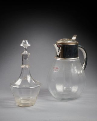 un pichet en verre et une carafe en verre posés sur une table