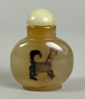a small glass bottle with a picture of a dog inside of it