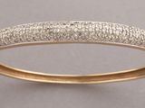 a close up of a gold bang with diamonds on it