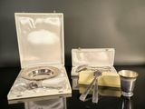 a silver plate and a silver cup on a table