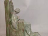 a figurine of a woman sitting on a bench