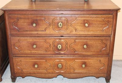 a wooden chest of drawers with a clock on top of it
