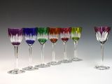 six verres à vin sont alignés sur une surface blanche