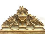 a mirror with a gold frame with a vase on it