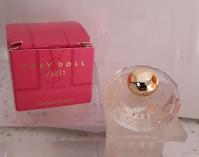 une photo d'un flacon de parfum et de son coffret posés sur un comptoir