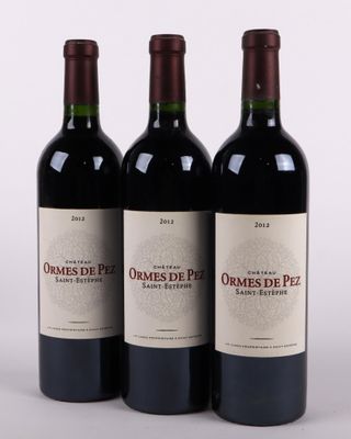 trois bouteilles de vin rouge posées côte à côte sur une table