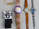 trois montres et un bracelet de montre posés sur une table
