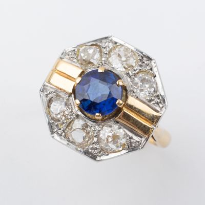 Gros plan sur une bague en saphir et diamants posée sur une surface blanche