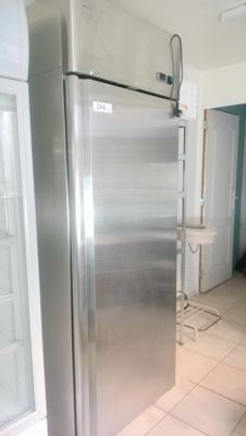a stainless steel refrigerator in the middle of a kitchen