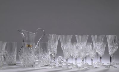 beaucoup de verres à vin et un pichet posés sur une table