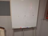 a white board on a stand in the corner of a room