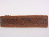 an old wooden box with carvings on it sitting on a white surface