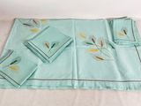 an image of a set of four placemats and napkins on a bed