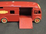 a red toy bus with a ramp on the side