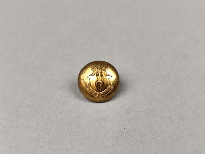 un gros plan d'un bouton doré sur une surface blanche