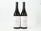 deux bouteilles de vin rouge posées l'une à côté de l'autre sur une surface blanche