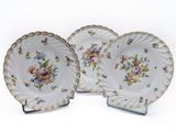 two plates with flowers on them on a white surface