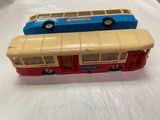 two toy buses that are sitting on a white surface