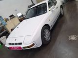 a white car parked inside of a building in a garage