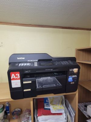 a printer sitting on top of a shelf in a room
