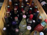 many bottles of alcohol in a wooden box on the floor