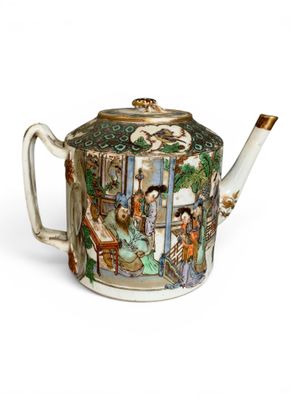 a teapot with a painting on it sitting on a table