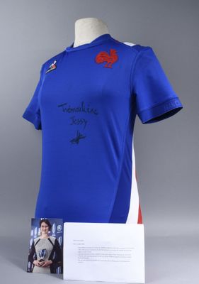 a blue shirt with a red poppy on it and a card on a mannequin