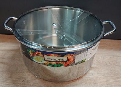 une grande casserole en métal avec un couvercle, posée sur une table en bois