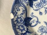 a blue and white plate with a flower design on it