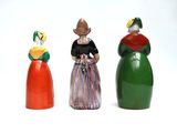 three figurines of different colors on a white surface