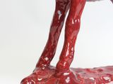 a red statue of a horse on a white surface