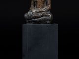une image représentant une statue d'une personne assise sur un socle