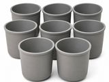 six gray plastic cups are arranged in a circle on a white surface
