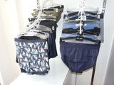many pairs of underwear hanging on a rack in a closet
