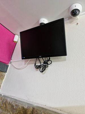 a flat screen tv mounted on the wall next to a wall mounted camera