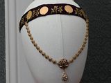 a mannequin headpiece with a gold chain and a cross on it