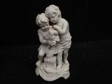 figurine of a boy and a girl holding a basket of flowers