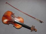 a violin and a bow on a gray surface