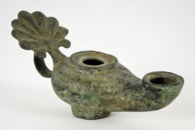 a small green vase that has a leaf on it