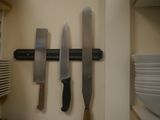 three knives hanging on the wall in the kitchen
